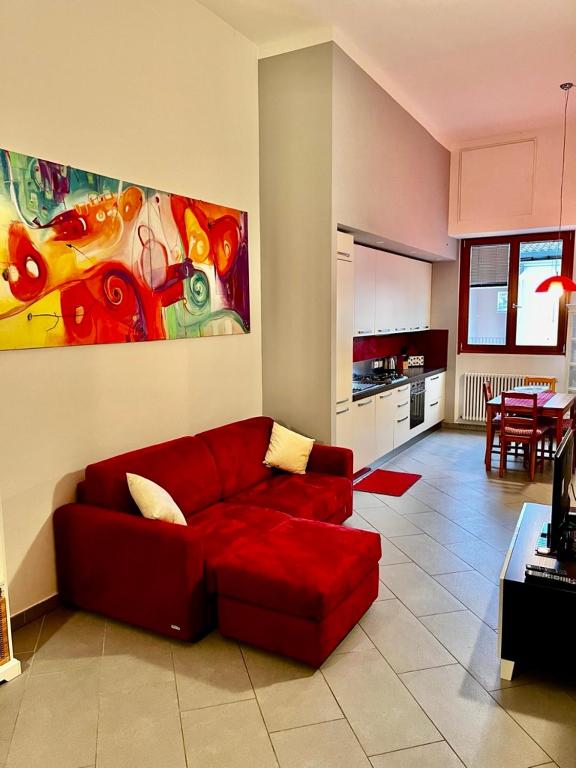 una sala de estar con un sofá rojo y una pintura en Ca Mimì in centro, en Rávena