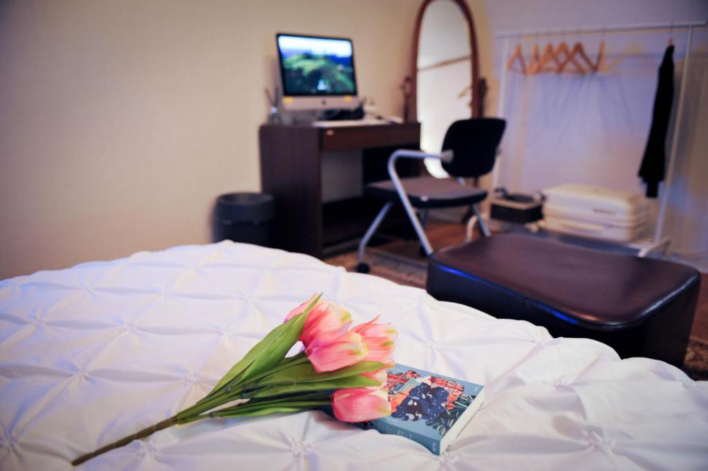 un ramo de flores rosas sentado en una cama en QQQ 3room spacious house at Jamsil en Seúl