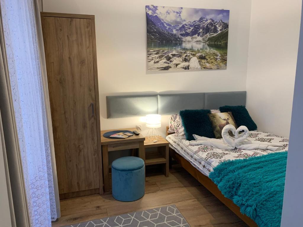 een slaapkamer met een bed en een bureau met een lamp bij Pokój 2 osobowy z aneksem kuchennym in Zakopane