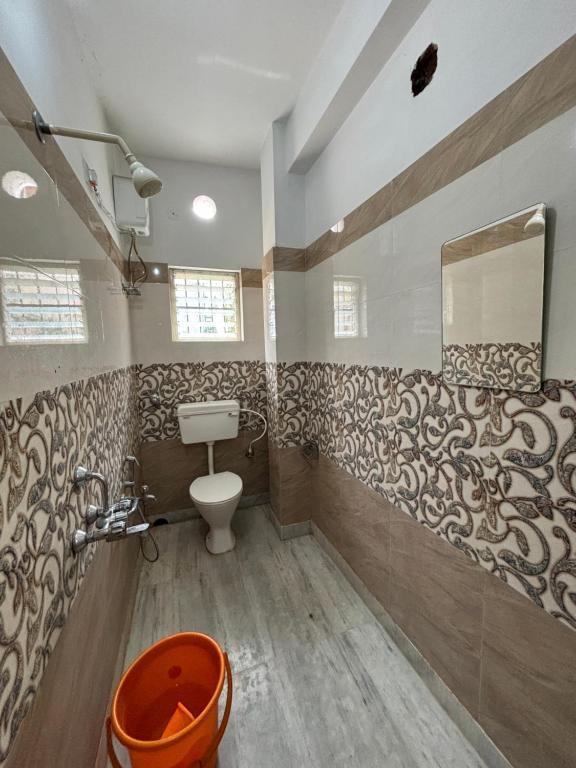 y baño con aseo y espejo. en Garden Guest House near rene tower, acropolis mall, en Calcuta