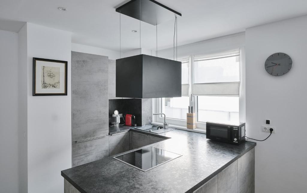 a kitchen with a sink and a clock on the wall at Wohnen in Wattens Top 3 in Wattens