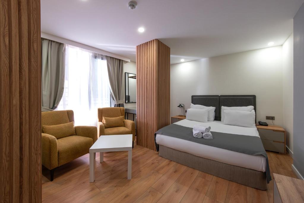 a hotel room with a bed and two chairs at Verde Mare Hotels in Antalya