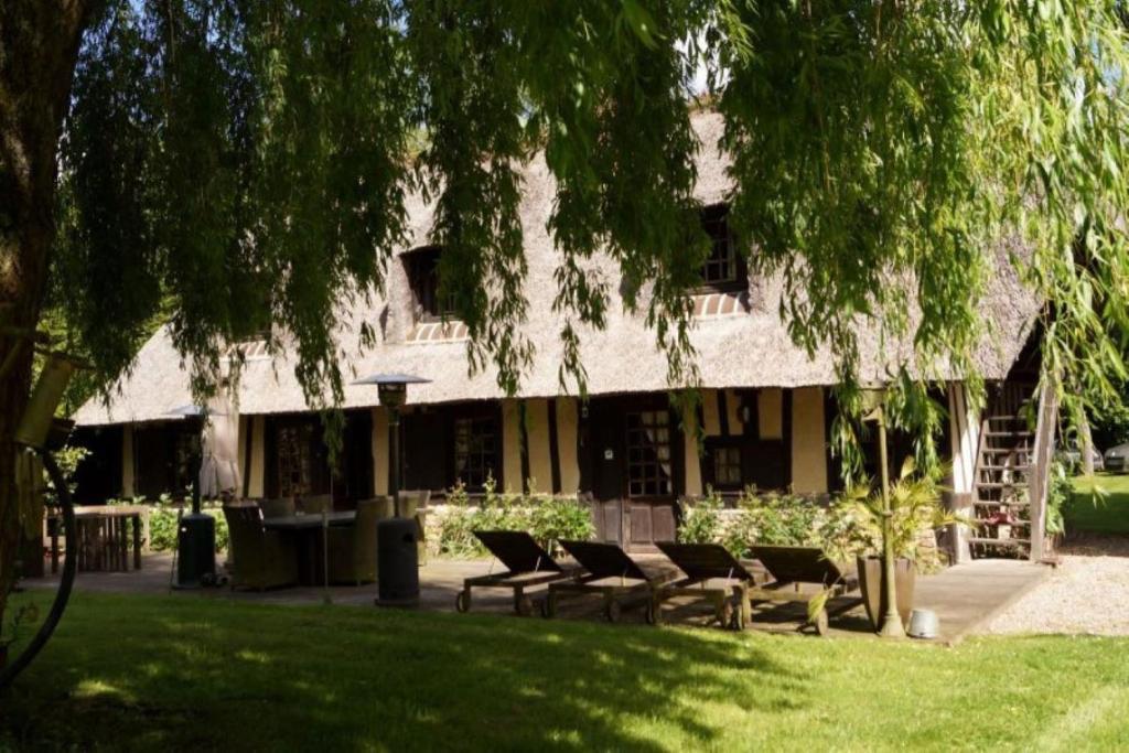 a building with a group of chairs in a park at chaumière familiale weekend & vacances paisible in Saint-Philbert-sur-Risle