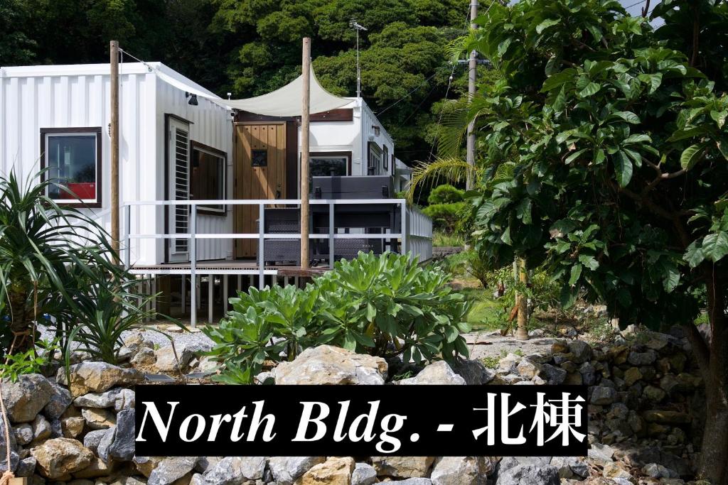 une petite maison dans un jardin avec les mots nord dans l'établissement Vacation Village Okinawa - Yambaru, à Nakijin