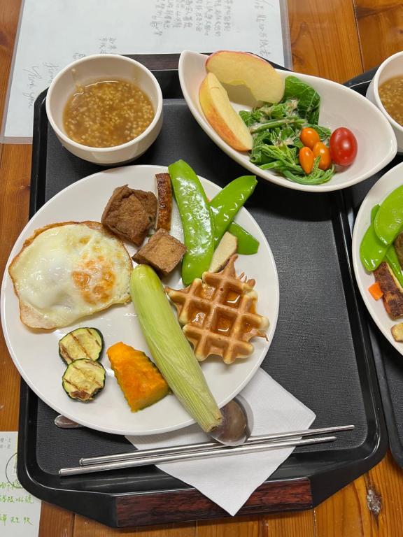 a tray of food with a plate of breakfast foods at Zhong Ming Ju Taoyi Fang in Fanlu