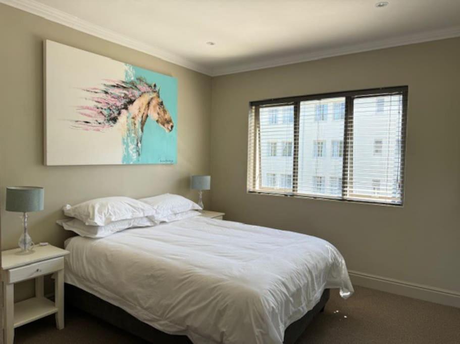 a bedroom with a bed with a painting of a horse at Luxury Townhouse in Stellenbosch CENTRAL (BACK-UP POWER) in Stellenbosch