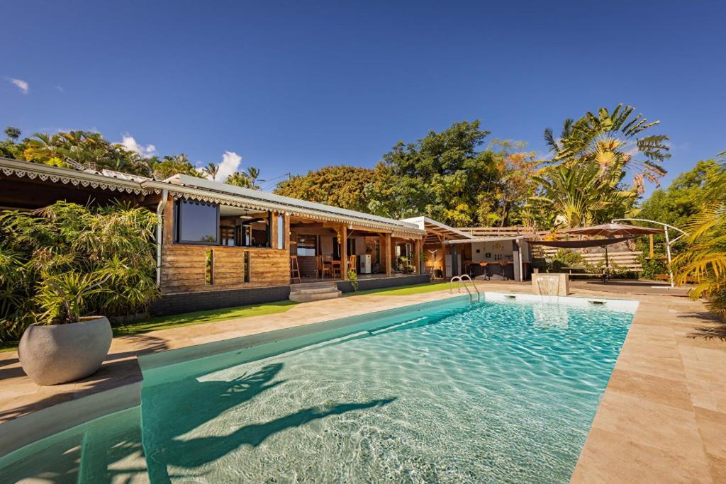- une piscine en face d'une maison dans l'établissement La Vanilleraie Apt 45m2 piscine jardin tropical parking privé, à Saint-Leu