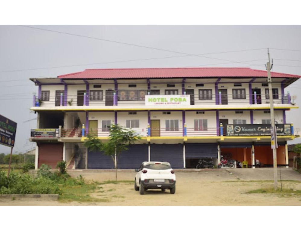 a white car parked in front of a building at Hotel Poba, Jonai, Assam 