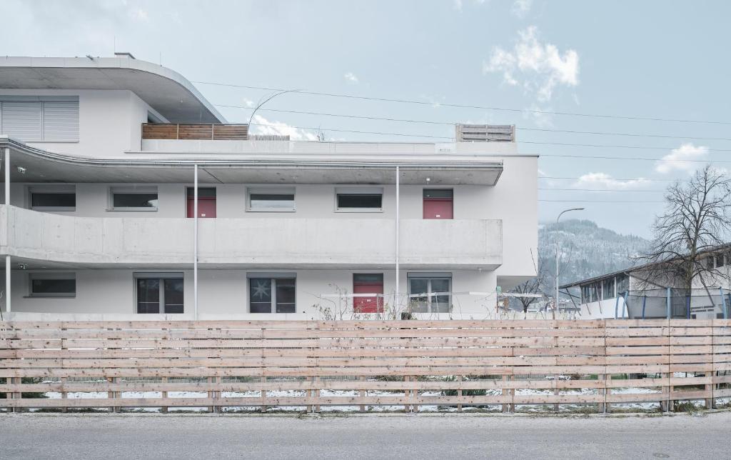 a white building with a fence in front of it at Wohnen in Wattens Top 5 in Wattens