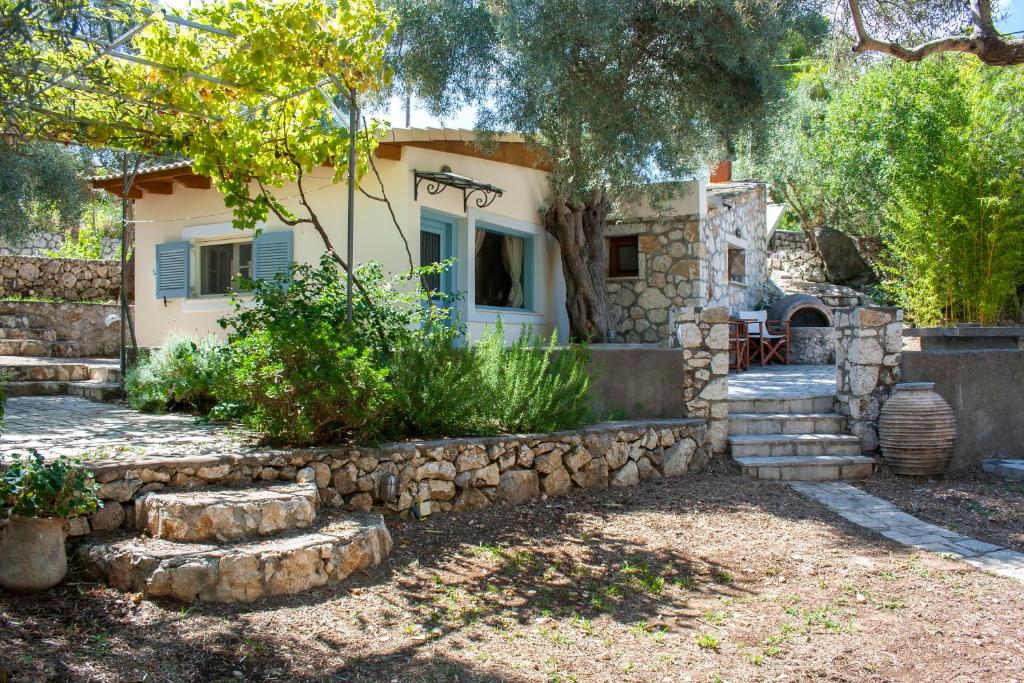 ein Haus mit einer Steinmauer davor in der Unterkunft Olive Grove Cottage - Excellent View in Lefkada Town