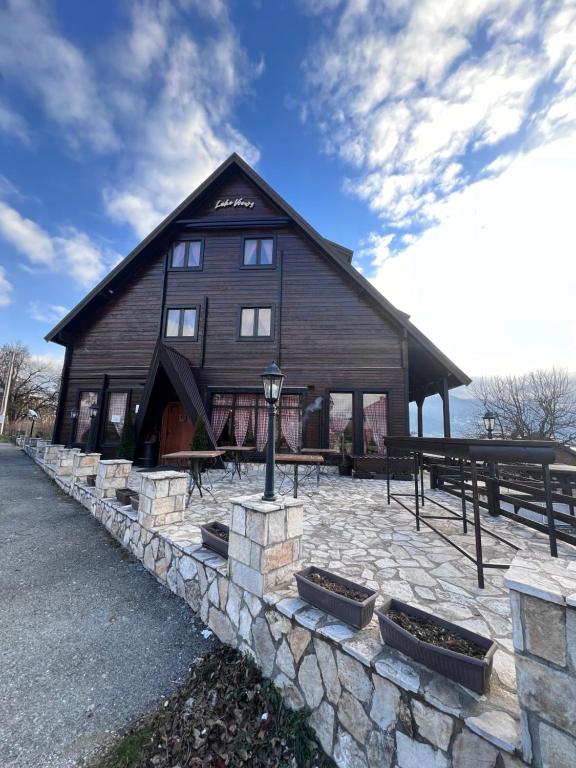 a large wooden barn with a stone wall at Camp Hotel Lake Views in Plav