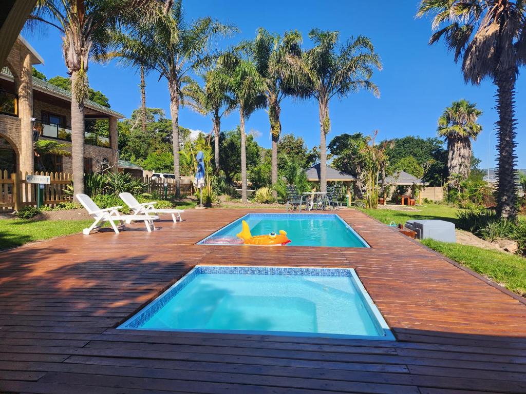 a swimming pool on a wooden deck next to a house at Lagoon Breeze Guest House in Knysna
