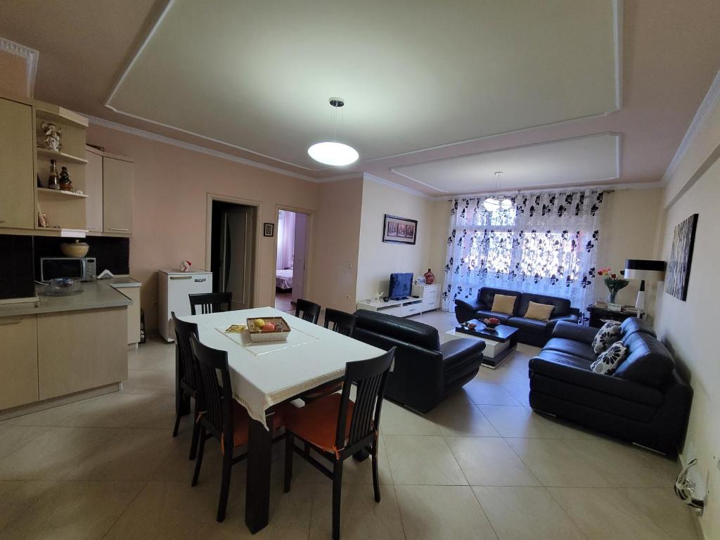 cocina y sala de estar con mesa y sofá. en Elbasan modern apartment city center, en Elbasan