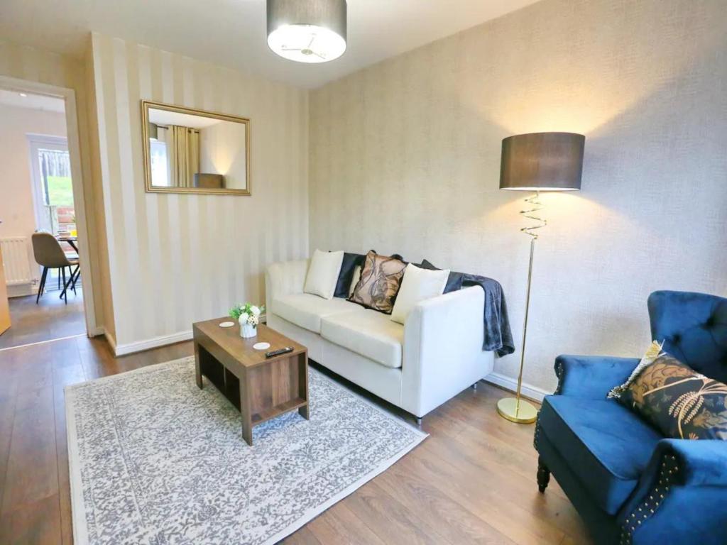 ein Wohnzimmer mit einem weißen Sofa und einem Tisch in der Unterkunft Pass the Keys King Bed Family Home With Parking WM Discounts in Manchester