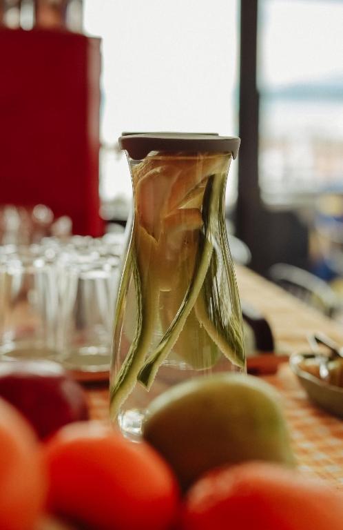 a glass vase sitting on top of a table with tomatoes at Limon Inn Hotel, Taşucu in Tasucu