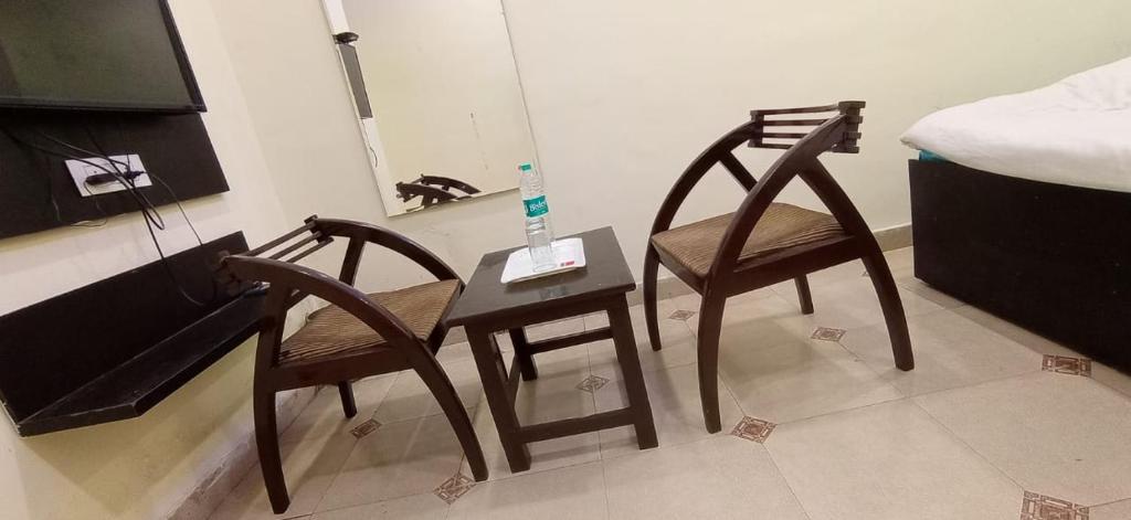 2 sillas y una mesa en una habitación con cama en Hotel Amar Inn, en Jalandhar
