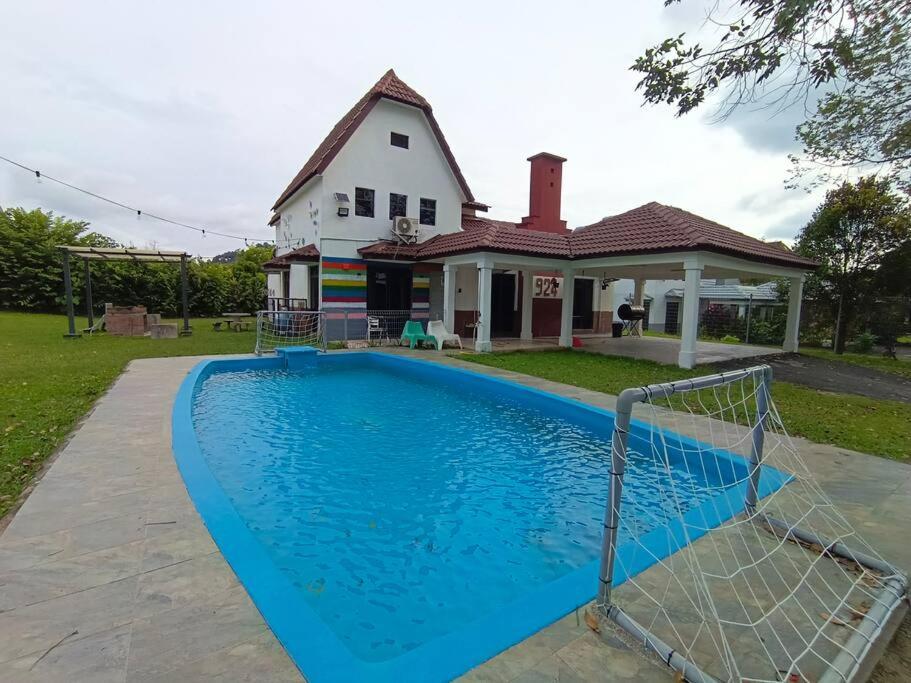 una casa con piscina di fronte a una casa di A’famosa Moments villa 924 covered Bbq KTV pool a Kampong Alor Gajah