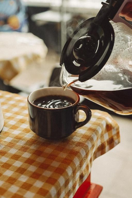 a cup of coffee is being poured into a coffee pot at Limon Inn Hotel, Taşucu in Tasucu