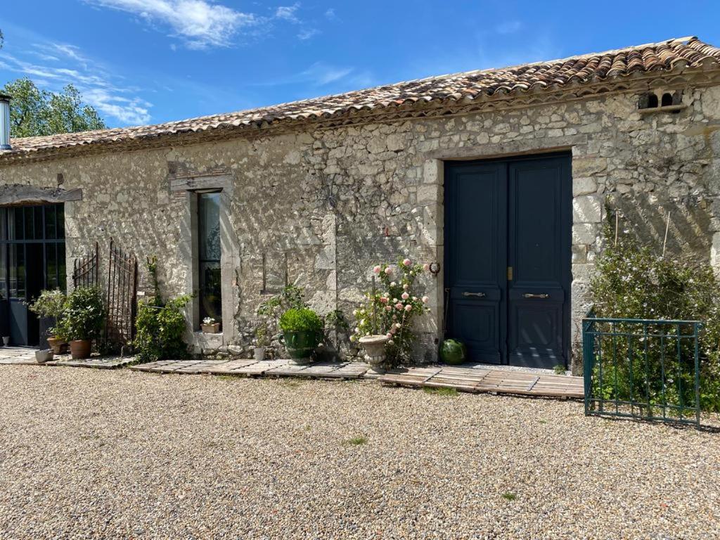 a stone building with a blue door and some plants at Maison de Vacances avec Piscine Privée en Dordogne in Boisse