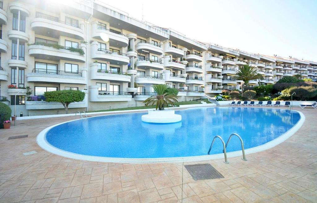 a large swimming pool in front of a building at Estupendo apartamento en San Vicente do Mar O Grove in San Vicente do Mar