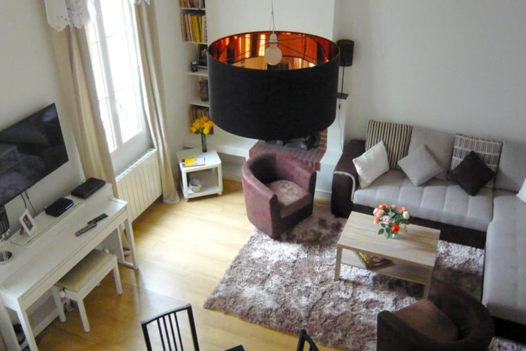 uma sala de estar com um sofá e uma mesa em LE REGRATTIER ST LOUIS em Paris