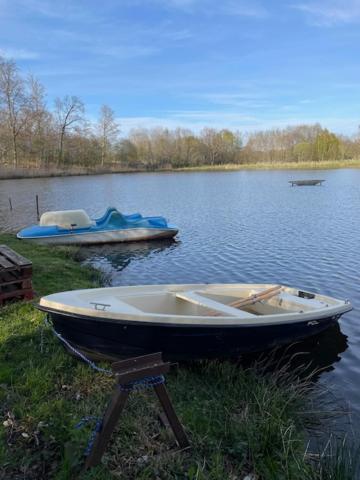 a boat on a stand in the grass on a lake at Dolina Trzech Stawów in Połczyn-Zdrój