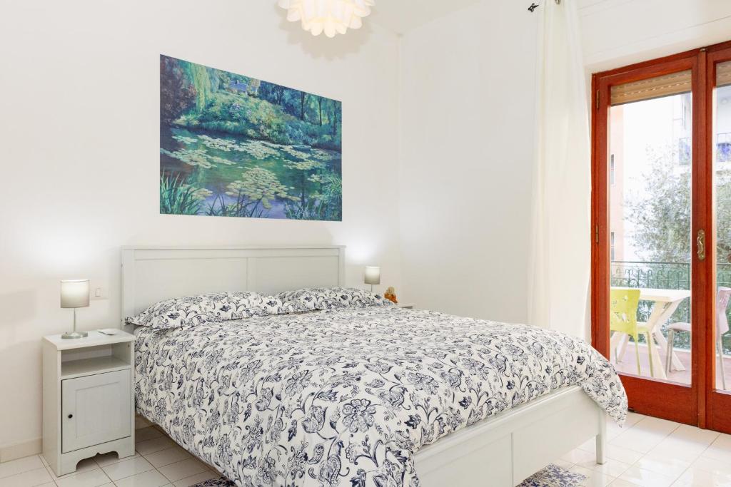 a white bedroom with a bed and a window at Residence Sorrento 2 in Sorrento