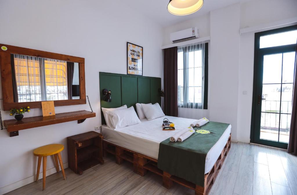 Schlafzimmer mit einem Bett mit einem grünen Kopfteil in der Unterkunft Limon Inn Hotel, Taşucu in Tasucu