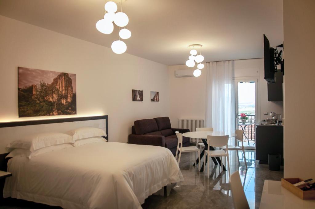 ein Schlafzimmer mit einem Bett, einem Tisch und einem Stuhl in der Unterkunft LeTagghjate - Exclusive Rooms and Suites in San Giorgio Ionico