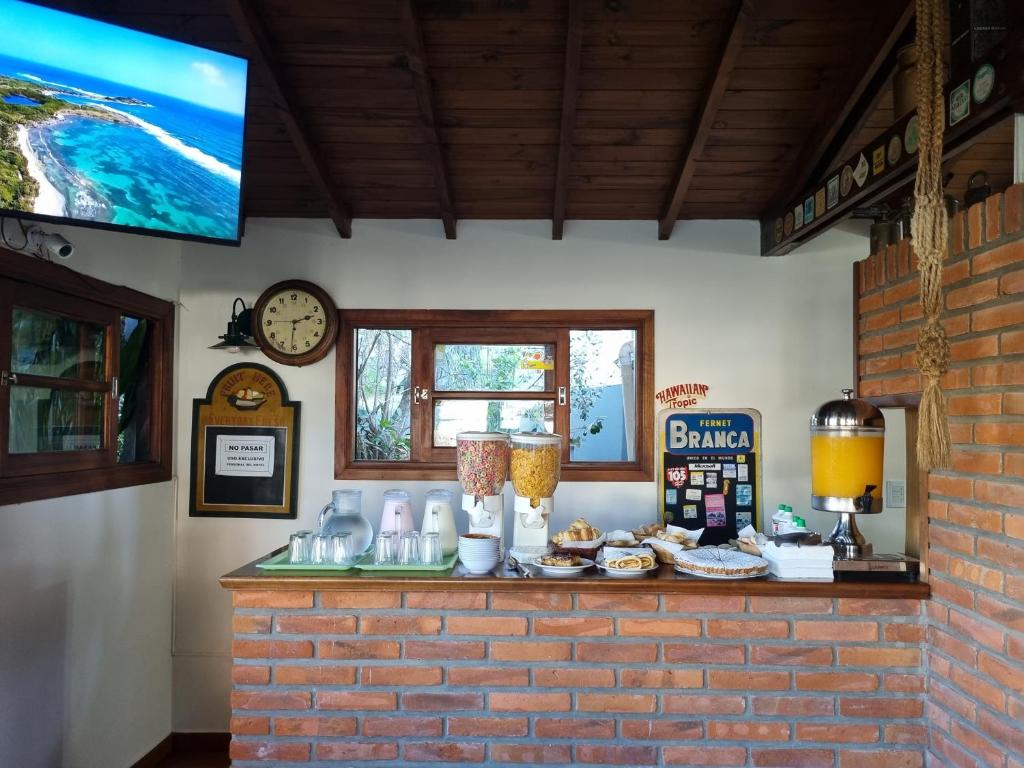 a counter with food and drinks on it with a clock at Hosteria Olimpo in Villa Gesell