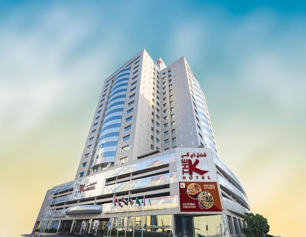 um edifício alto com um sinal em frente em The K Hotel em Manama