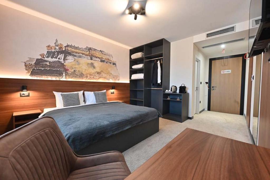 a bedroom with a bed and a couch at Tvrdjava Rooms in Novi Sad