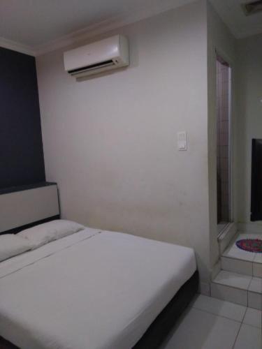 a white bedroom with a white bed and a window at Hotel Rim Global Pj21 in Kampong Baharu Sungai Way