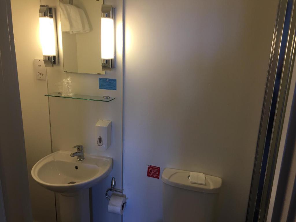 a white bathroom with a sink and a toilet at The Anchor Hotel & Bars in Ingoldmells