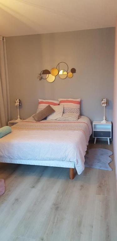 ein Schlafzimmer mit einem großen Bett mit zwei Leuchten an der Wand in der Unterkunft Chambre cosy in Niort