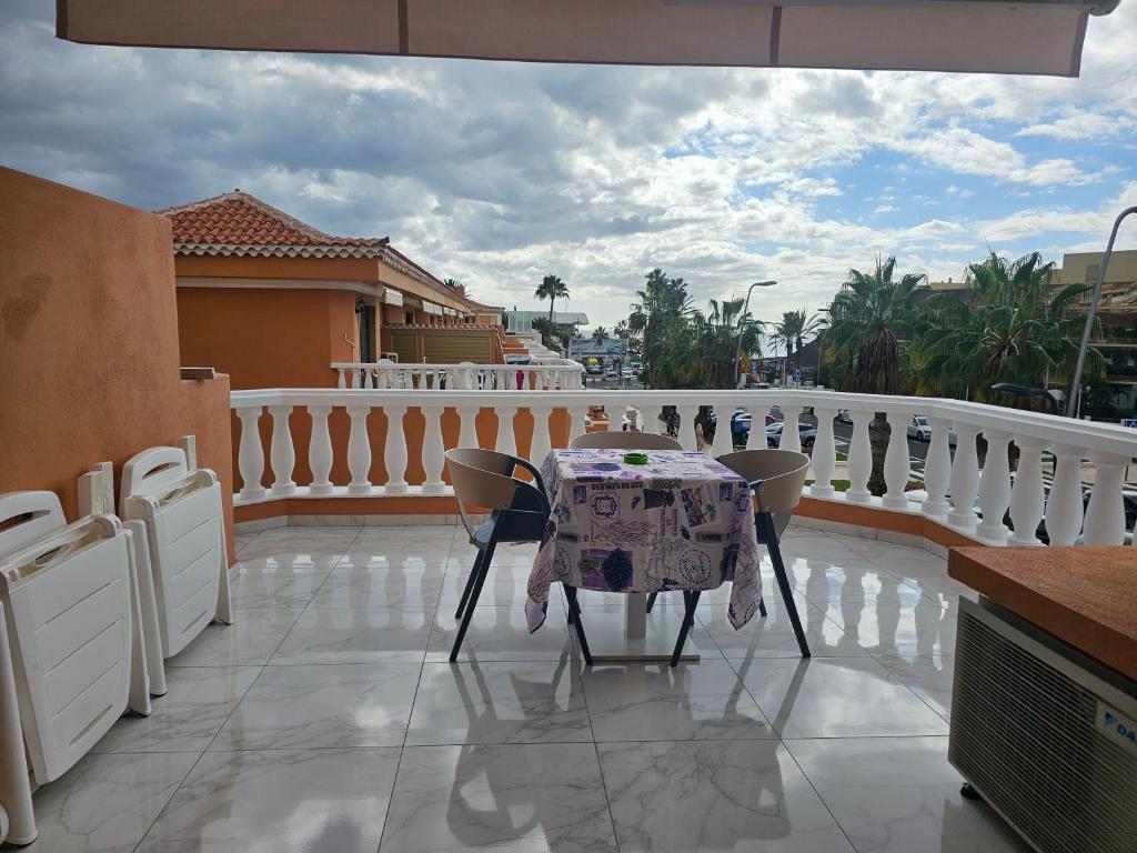 einen Tisch und Stühle auf einem Balkon mit Aussicht in der Unterkunft Tenerife Royal Gardens - Las Vistas TRG - Viviendas Vacacionales in Playa de las Americas