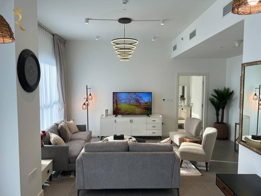アブダビにあるAmericana Cove - Elegant 1BR Apartment in Al Reem Near Reem Mallのソファとテレビのあるリビングルーム