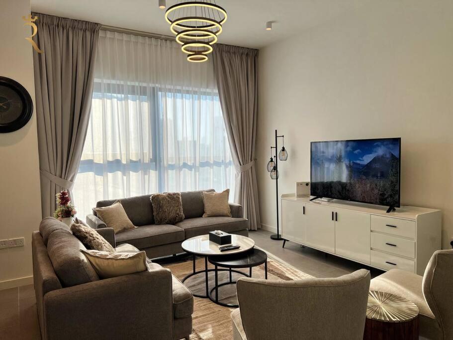 a living room with a couch and a tv at 1BR Americana Apartment: Stars and Stripes Haven in Abu Dhabi