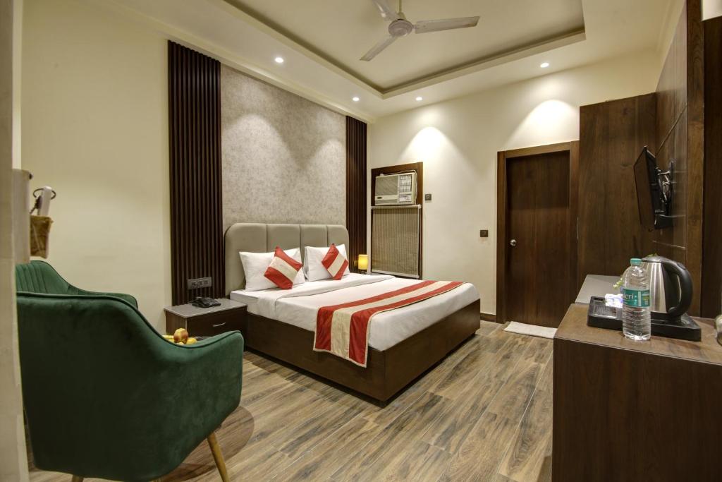 a hotel room with a bed and a chair at HOTEL KASHISH PLAZA in New Delhi