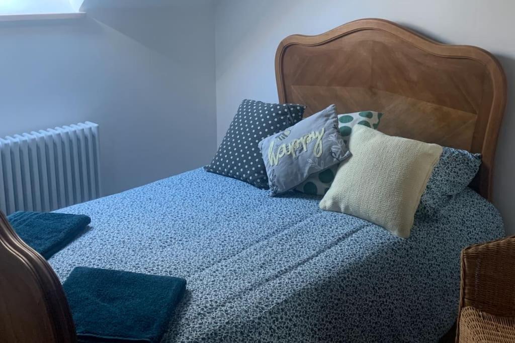 ein Bett mit blauer Bettwäsche und Kissen darauf in der Unterkunft The Chamberet Grand Coeur in Chamberet