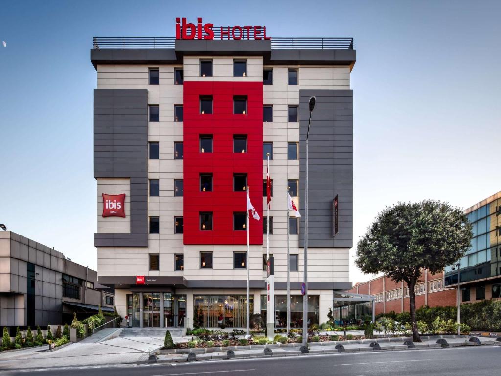 a hotel with a red building on a street at Ibis Istanbul West in Istanbul