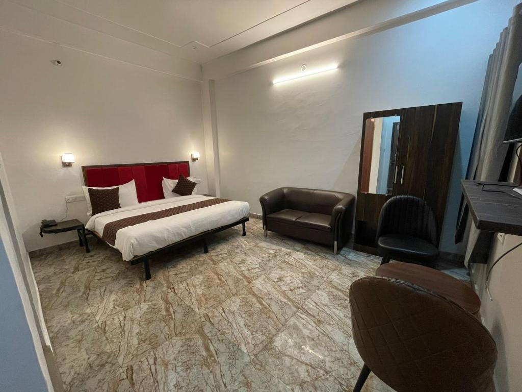 Hotel Sangam View في الله أباد: غرفه فندقيه بسرير وكرسي