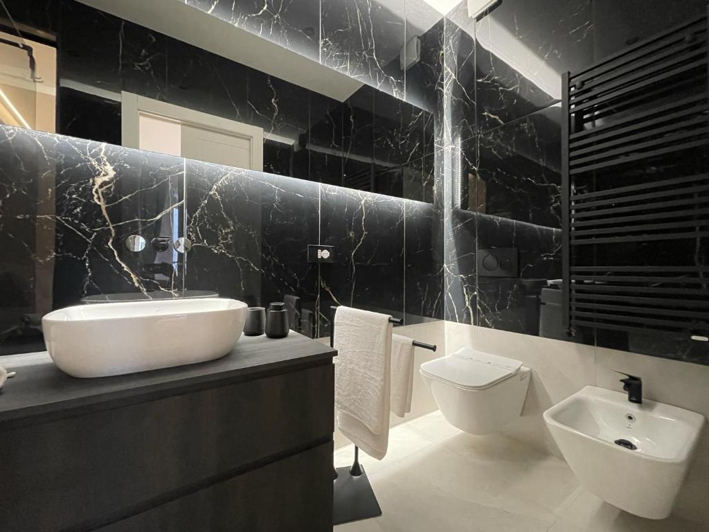 a black and white bathroom with a sink and a toilet at B and G San Babila luxury in the heart of Milano - Design district in Milan