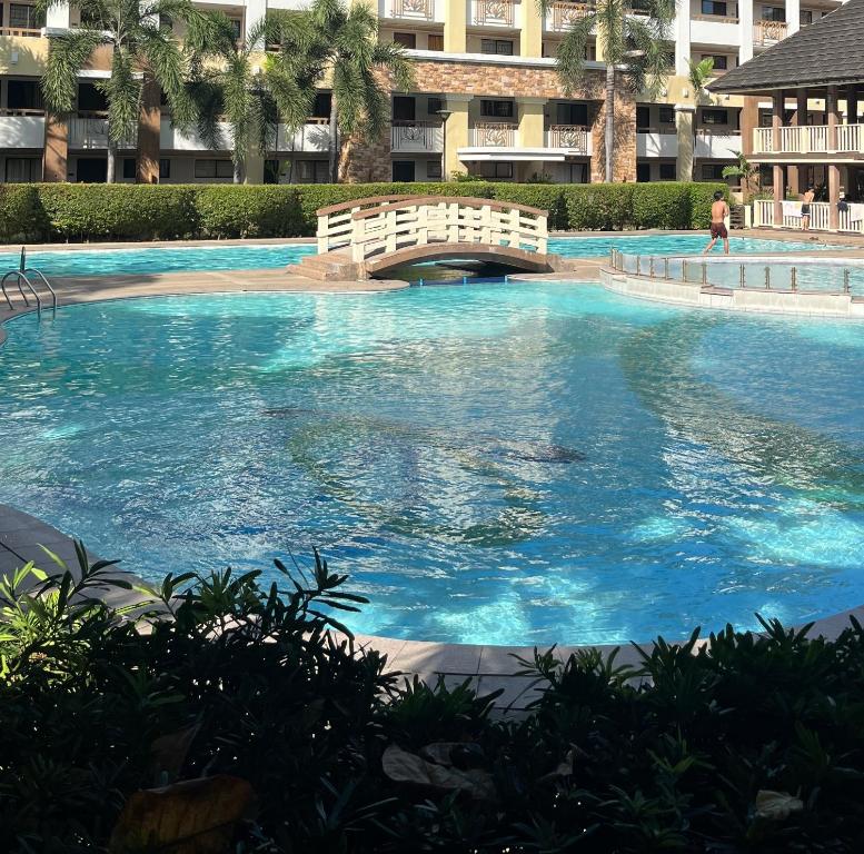 ein großer Pool mit blauem Wasser und einer Brücke in der Unterkunft Scandinavian design 2BR @ Ortigas, Pasig in Manila