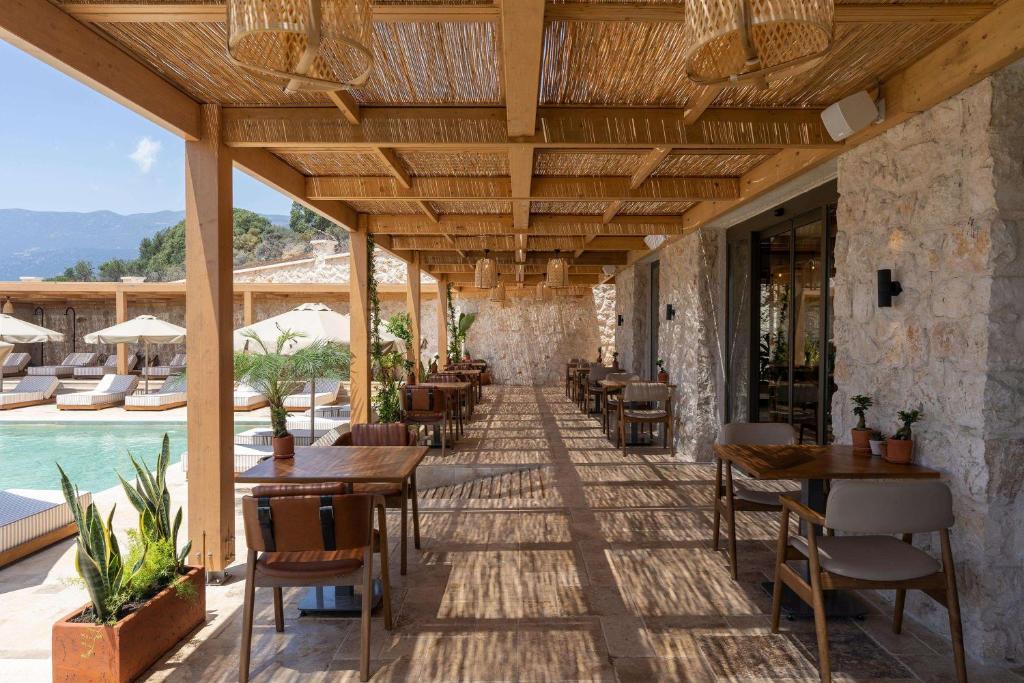 a restaurant with tables and chairs next to a pool at Radisson Blu Hotel, Kas in Kaş