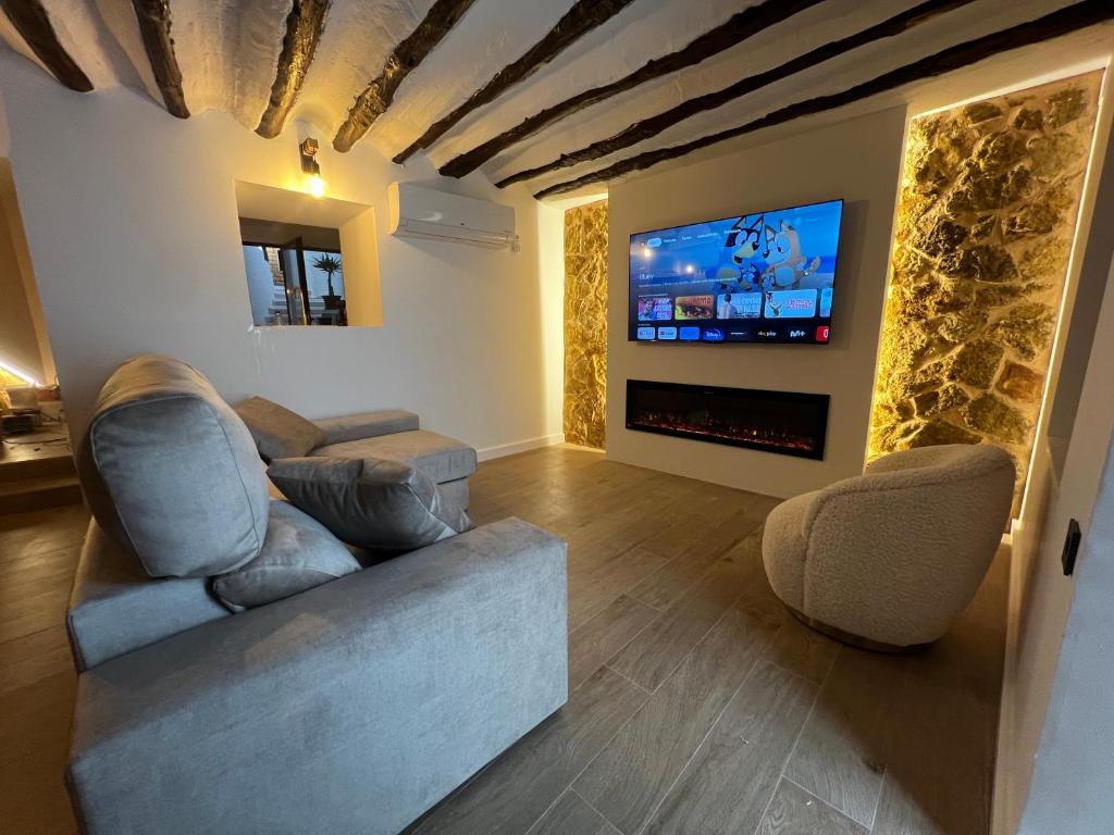 a living room with two chairs and a tv at Casa Rural Hoyo del moro in Liétor