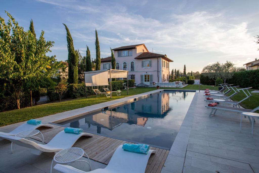 a villa with a swimming pool in front of a house at Villa Montefalcone: Charm, Private Pool, and Chef in Orentano