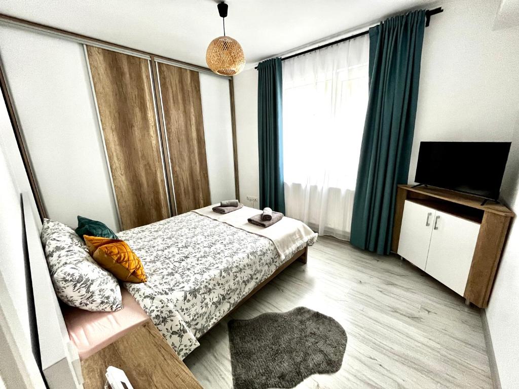 a small bedroom with a bed and a television at New cozy apartment in Otopeni near airport in Otopeni