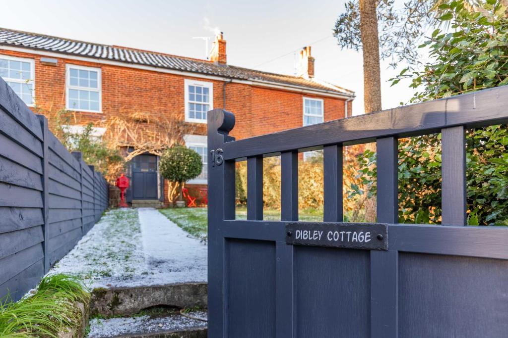 a black fence in front of a house at Dibley Cottage Mundesley in Mundesley