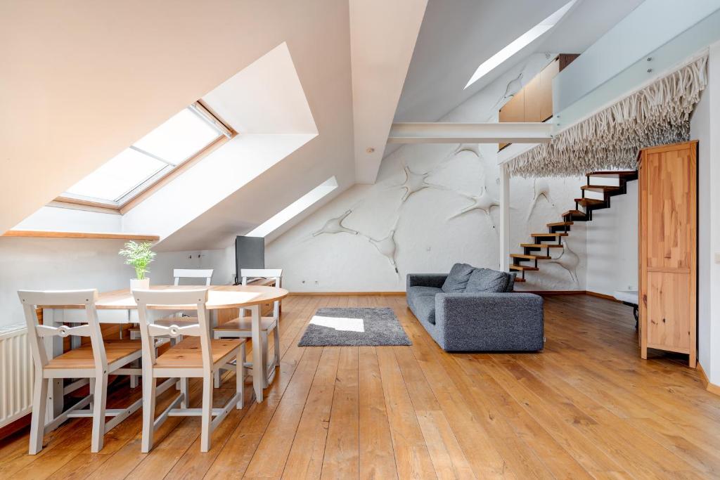 een woonkamer met een tafel en stoelen en een trap bij Charming Loft in Vilnius Oldtown in Vilnius